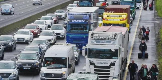 People making their way, on foot with luggage to bypass the traffic on Dublin's M50 north-bound towards the airport on Thursday
