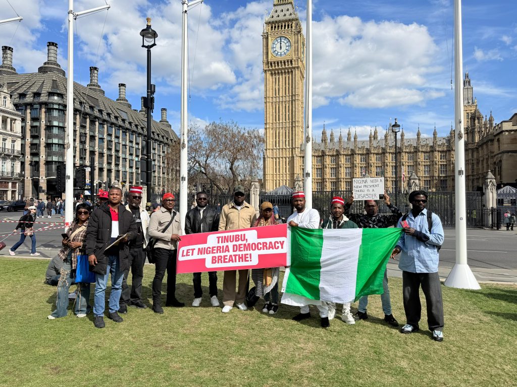 Nigerians Unite protesters gather at Parliament Square, Westminster, April 19, 2026. Banners call for electoral reform. / PIXEL PULSE