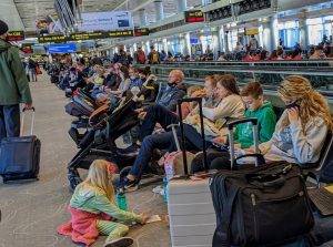 A crowded airport terminal with long queues at check-in or boarding gates