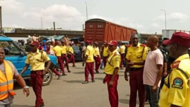 A busy Lagos highway with heavy traffic congestion, emergency responders at a crash scene, and LASTMA officers managing traffic flow during peak hours.