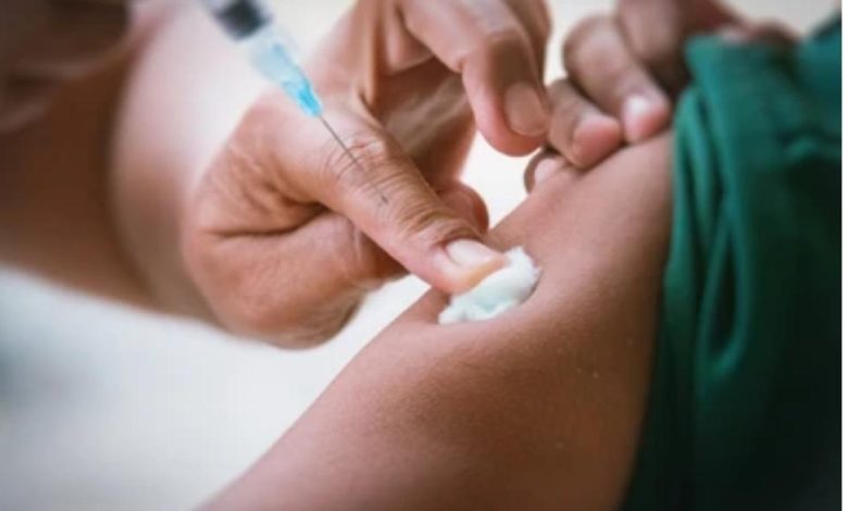 A healthcare worker administering an injection in a clinical setting